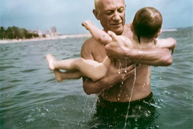 Pablo Picasso plays in the water with his son Claude.