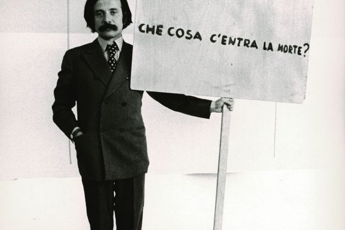 Achille Bonito Oliva con il cartello di Gino De Dominicis
