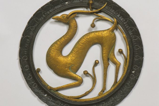 Azulejo circular dorado que representa a un ciervo.