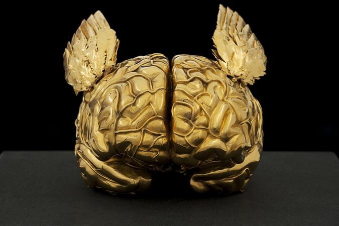Goldenes menschliches Gehirn mit Engelsflügeln