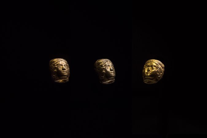 Colgantes de cabeza femenina gianiforme en oro de la tumba 604