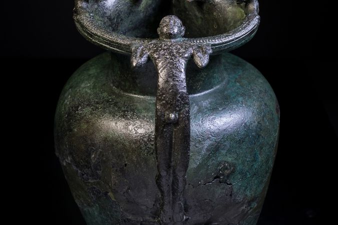 Jarra con pico (schnabelkanne) de tipo etrusco con asa configurada, accesorio de palmeta y leones aplicados, de la tumba 1