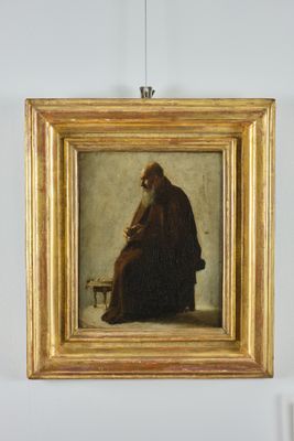 Fraile capuchino sentado con caja de rapé en la mano