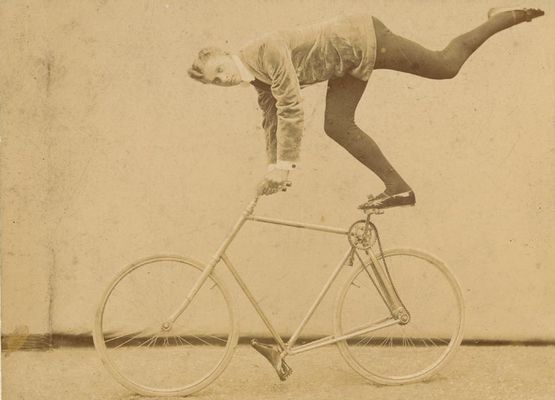 Acrobata in equilibrio funambolico su una bicicletta