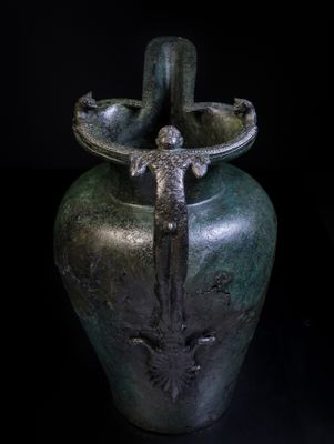 Jarra con pico (schnabelkanne) de tipo etrusco con asa configurada, accesorio de palmeta y leones aplicados, de la tumba 1