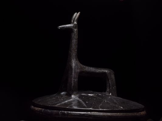 Olla mit geometrischem Dekor auf dem Körper und runden stilisierten Enten auf der Schulter_ Deckel mit Griff in Form eines stilisierten Vierfüßlers. Aus Grab 415