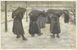 Mujeres cargando sacos de carbón en la nieve.